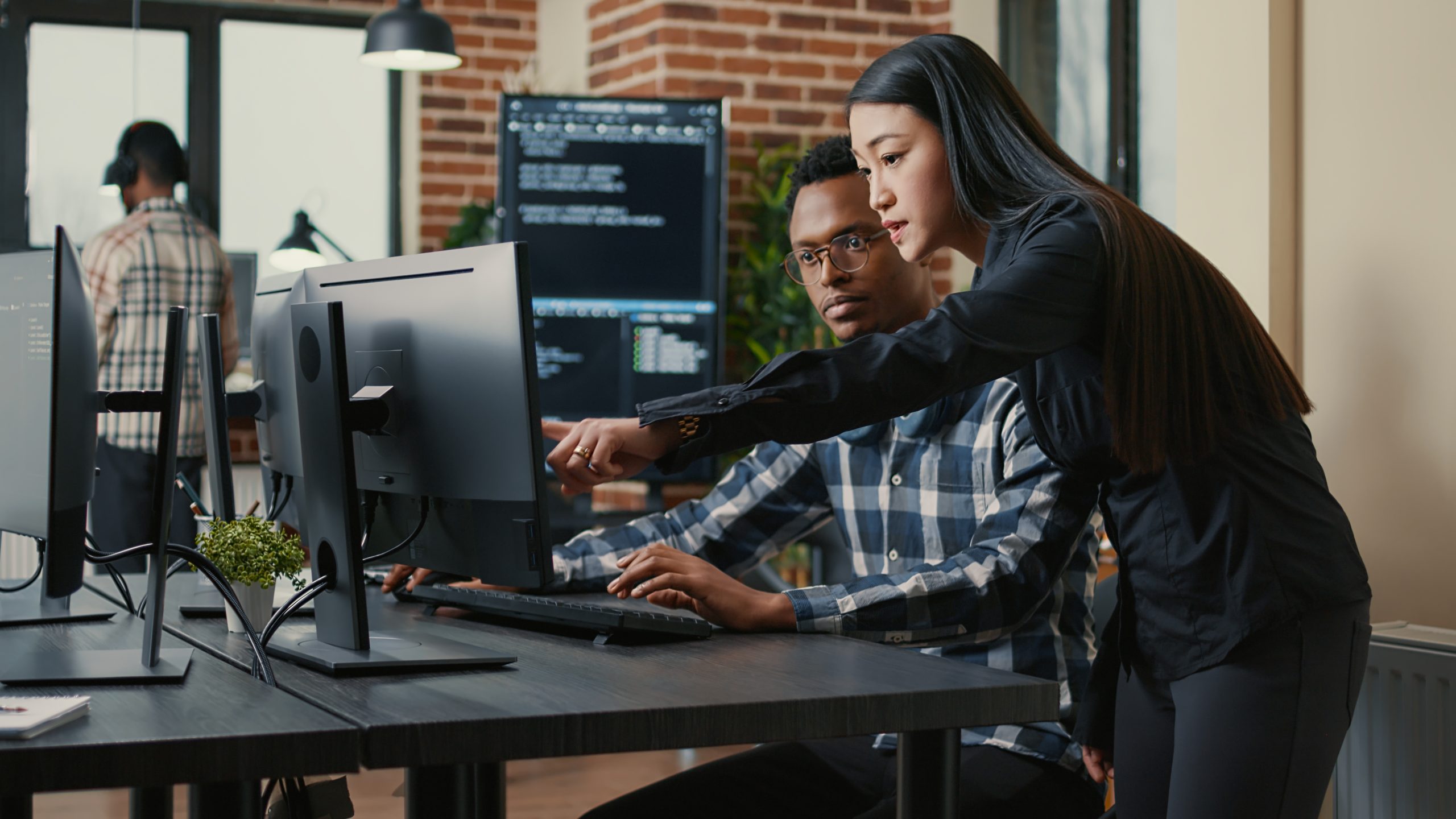 2 people discussing something that is on a computer screen.